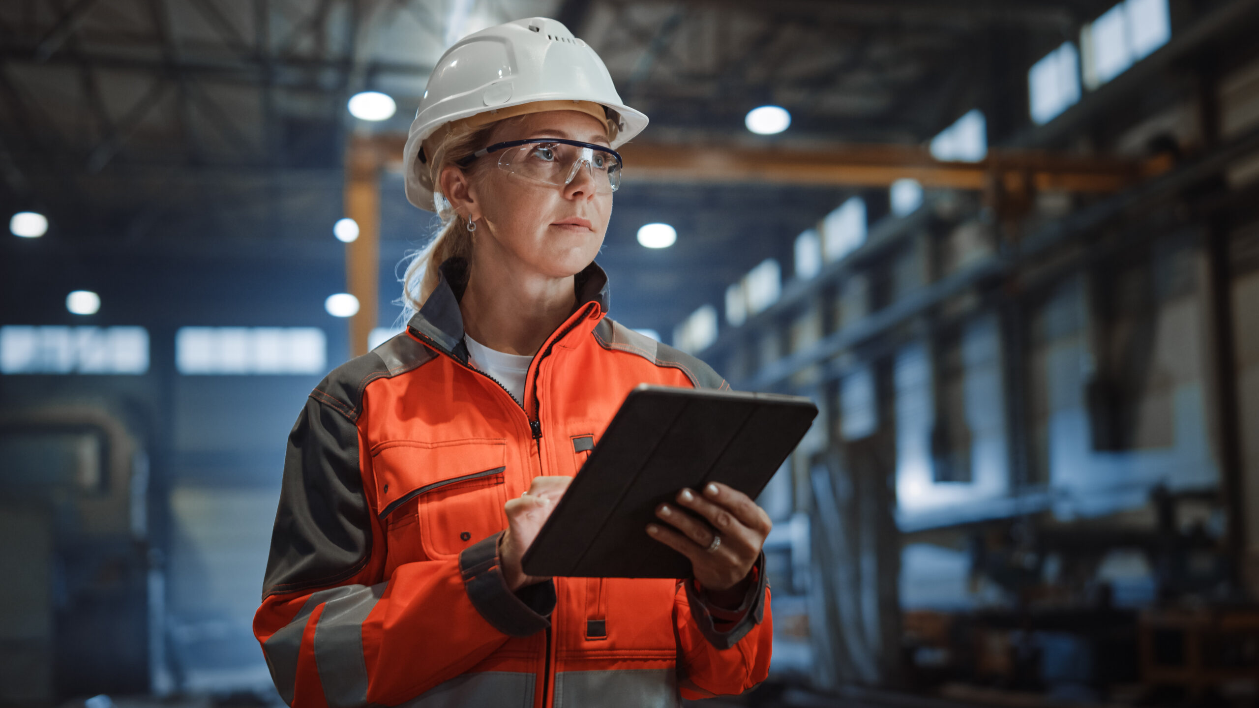 a woman wearing a safety helmet, jacket, and glasses